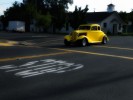 An old car crossing an intersection.